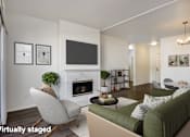 Thumbnail 6 of 34 - A living room with a green couch and a fireplace.