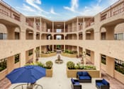 Thumbnail 2 of 34 - a courtyard with seating and a fountain in the middle of a building