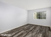 Thumbnail 9 of 53 - A room with unaltered wooden flooring and a window with blinds.