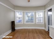 Thumbnail 7 of 18 - A room with unaltered wooden flooring and white walls.
