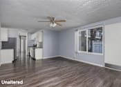 Thumbnail 14 of 36 - A room with a ceiling fan and wooden flooring.