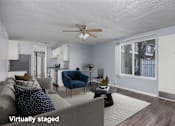 Thumbnail 15 of 36 - A living room with a grey couch and a blue chair.