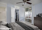 Thumbnail 22 of 36 - A bedroom with a bed, dresser, and a ceiling fan.