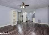 Thumbnail 12 of 36 - A room with a ceiling fan and unaltered wood flooring.