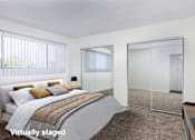 Thumbnail 14 of 28 - A bedroom with a bed, a mirror, and a lamp.