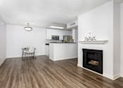 Thumbnail 26 of 33 - a living room with a fireplace and a kitchen