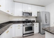 Thumbnail 30 of 33 - a kitchen with white cabinets and stainless steel appliances