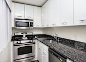 Thumbnail 23 of 33 - a kitchen with white cabinets and granite counter tops and stainless steel appliances
