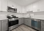 Thumbnail 2 of 33 - A kitchen with a stove, oven, and microwave.