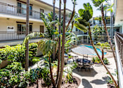 Thumbnail 1 of 41 - a patio with palm trees and a table and chairs