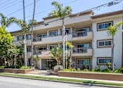 Thumbnail 4 of 41 - a white apartment building with palm trees in front of it