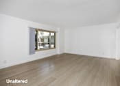 Thumbnail 8 of 41 - A room with a window and wooden flooring.