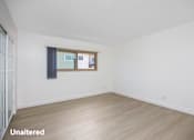 Thumbnail 14 of 41 - A room with unaltered flooring and a window with a view of buildings outside.