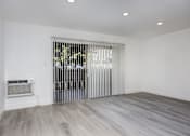 Thumbnail 20 of 63 - a living room with white walls and a sliding door to a patio