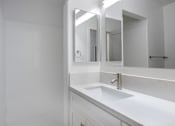 Thumbnail 24 of 63 - a white bathroom with a sink and two mirrors