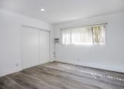Thumbnail 25 of 63 - an empty room with white walls and wood flooring and a white door and window