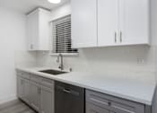 Thumbnail 17 of 63 - a kitchen with white cabinets and a sink and a window