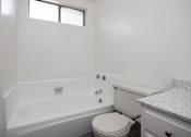 Thumbnail 16 of 18 - an empty bathroom with a toilet and a bath tub