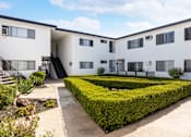 Thumbnail 2 of 18 - an exterior view of a building with hedges and a courtyard