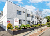Thumbnail 3 of 18 - a large white building with a sign in front of it