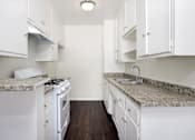 Thumbnail 12 of 18 - a kitchen with white appliances and granite counter tops and white cabinets