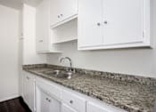 Thumbnail 13 of 18 - a kitchen with white cabinets and granite counter top and a sink