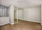 Thumbnail 31 of 45 - A room with a sliding glass door and wooden flooring.