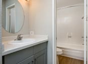 Thumbnail 34 of 45 - A bathroom with a sink, mirror, and bathtub.