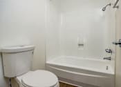 Thumbnail 45 of 45 - A white toilet and bathtub in a bathroom.