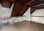 Thumbnail 42 of 45 - A room with wooden floors and a balcony with white railings.