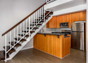 Thumbnail 35 of 45 - A kitchen with wooden cabinets and a stainless steel refrigerator.