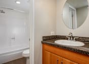 Thumbnail 40 of 45 - A bathroom with a white tub and sink.