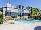 Thumbnail 21 of 45 - a swimming pool with chairs in front of a building