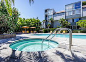 Thumbnail 44 of 45 - a hot tub in a pool with an apartment building in the background