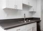 Thumbnail 13 of 19 - a kitchen with white cabinets and a sink