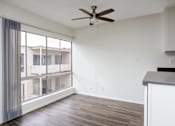 Thumbnail 17 of 19 - an empty living room with a large window and a ceiling fan