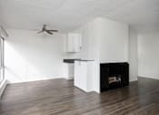 Thumbnail 11 of 19 - an empty living room with white walls and a fireplace