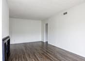 Thumbnail 12 of 19 - an empty living room with white walls and wood floors