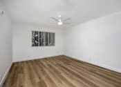 Thumbnail 40 of 52 - a living room with white walls and wooden floors and a ceiling fan