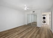 Thumbnail 41 of 52 - a living room with white walls and wood floors and a mirrored closet
