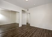 Thumbnail 24 of 34 - A room with a wooden floor and white walls.