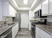 Thumbnail 26 of 53 - A kitchen with granite countertops and stainless steel appliances.