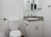Thumbnail 24 of 53 - A white toilet sits next to a sink in a bathroom.