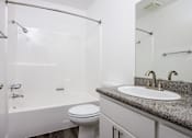Thumbnail 25 of 53 - A white bathroom with a toilet, sink, and bathtub.