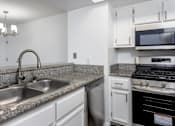 Thumbnail 18 of 53 - A kitchen with a stainless steel sink and a stove top oven.