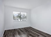 Thumbnail 20 of 53 - A room with a window and wooden flooring.