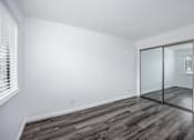 Thumbnail 21 of 53 - A room with a sliding glass door and wooden flooring.
