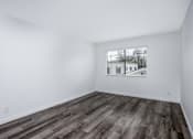 Thumbnail 22 of 53 - A room with wooden flooring and a window showing a building outside.