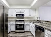 Thumbnail 47 of 53 - A modern kitchen with white cabinets and stainless steel appliances.