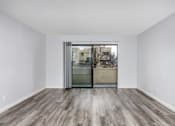 Thumbnail 50 of 53 - A room with a wooden floor and a sliding glass door.